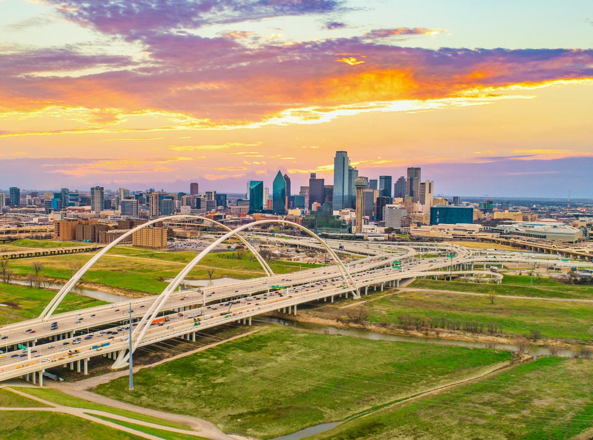 a bridge full of cars with buildings in the distance